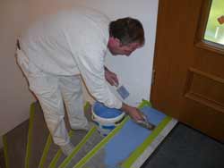 der Malermeister trägt den Bodenbelag fugenlos im zweiten Arbeitschritt auf.