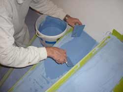 Ein Bodenbelag fugenlos wird durch den Malermeister in Blau aufgetragen